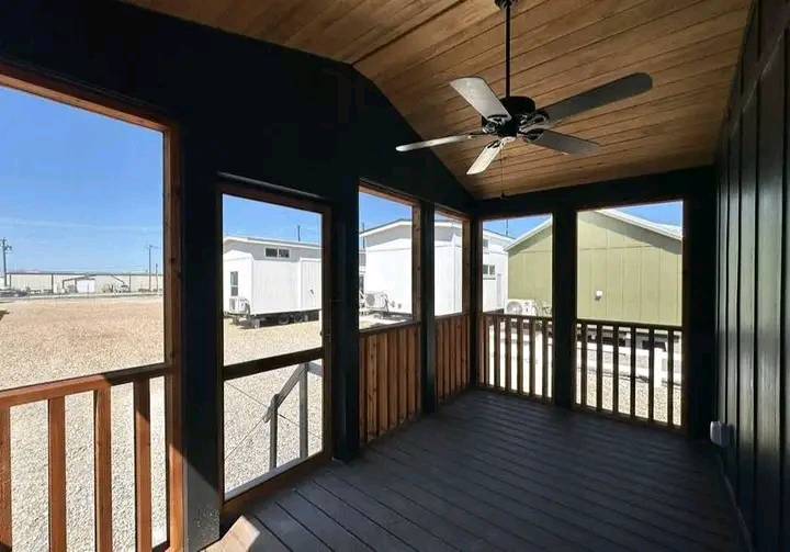 Spacious kitchen with dark wood cabinetry, stainless steel appliances, and a large marble island. Bright lighting and a sleek, modern aesthetic.