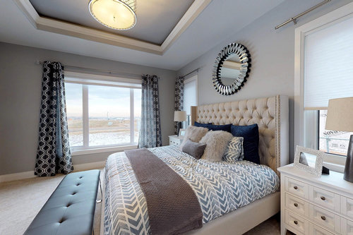 Luxurious bedroom with a tufted headboard, plush bedding, and decorative pillows. Large window with patterned curtains. Elegant, calm atmosphere.