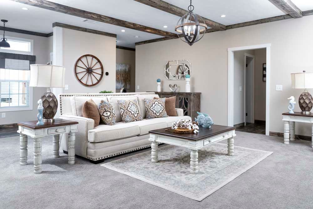 Stylish living room with a cream sofa, patterned pillows, and matching lamps. A rustic coffee table sits on a textured rug, complementing the cozy ambiance.