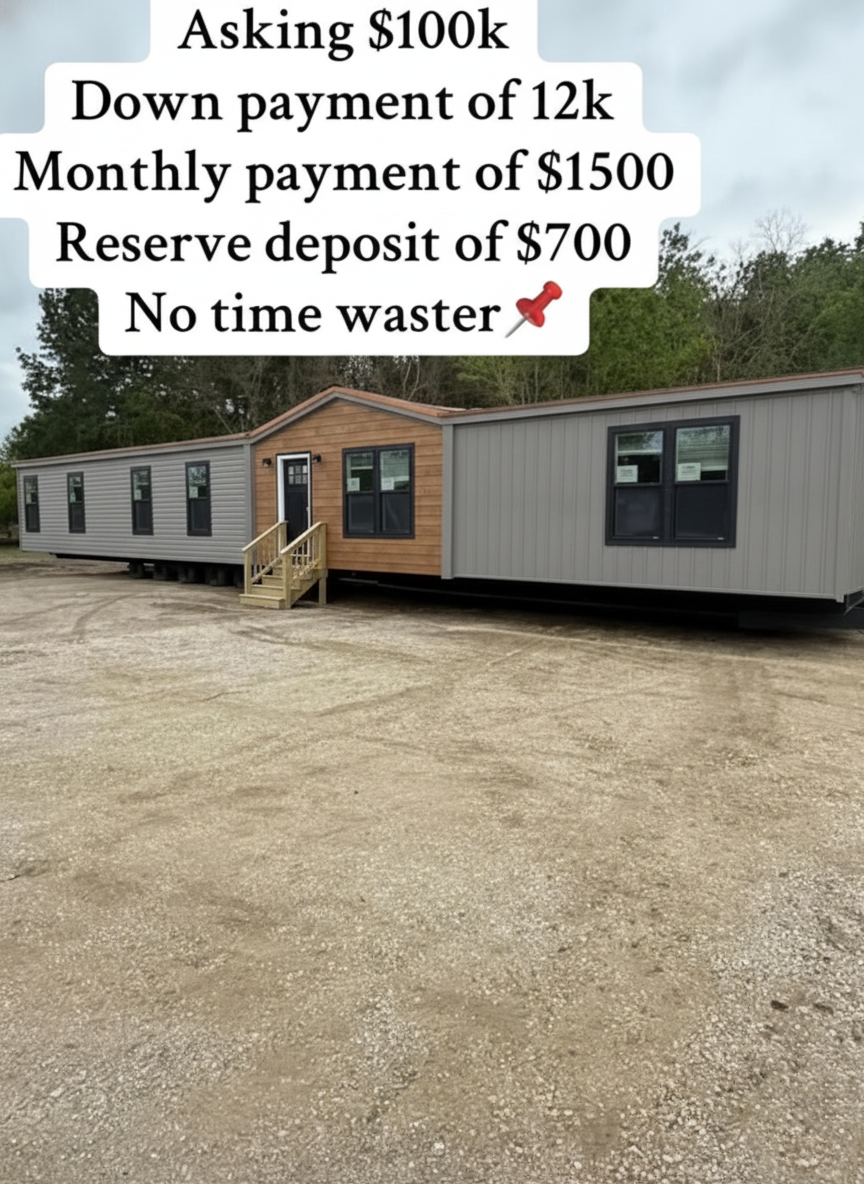 Long, gray manufactured home with a wooden entrance, set on a gravel lot. Overlaid text shows sale details: price, down payment, monthly cost.
