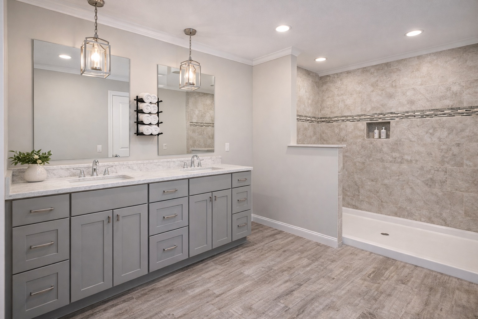 Spacious modern bathroom with gray double vanity, white countertop, large mirrors, pendant lights, walk-in shower, and wooden floor. Calm, elegant feel.