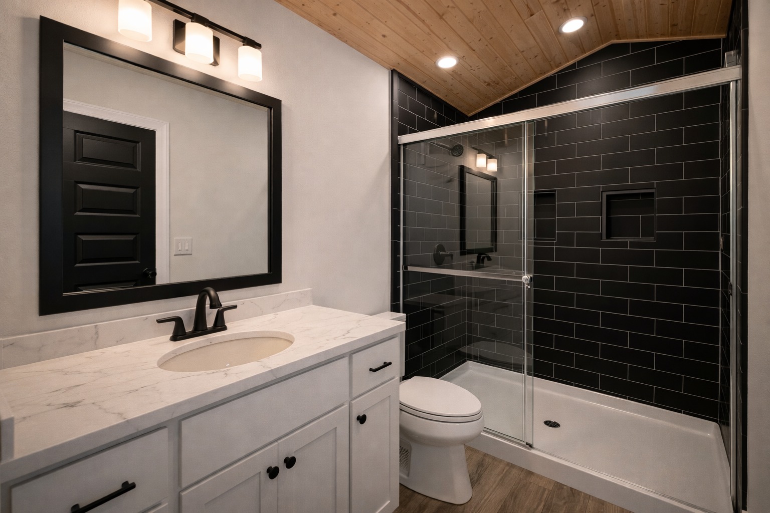 Modern bathroom with a white vanity, marble countertop, and black faucet. A glass-enclosed shower with black tiled walls complements wood ceiling.