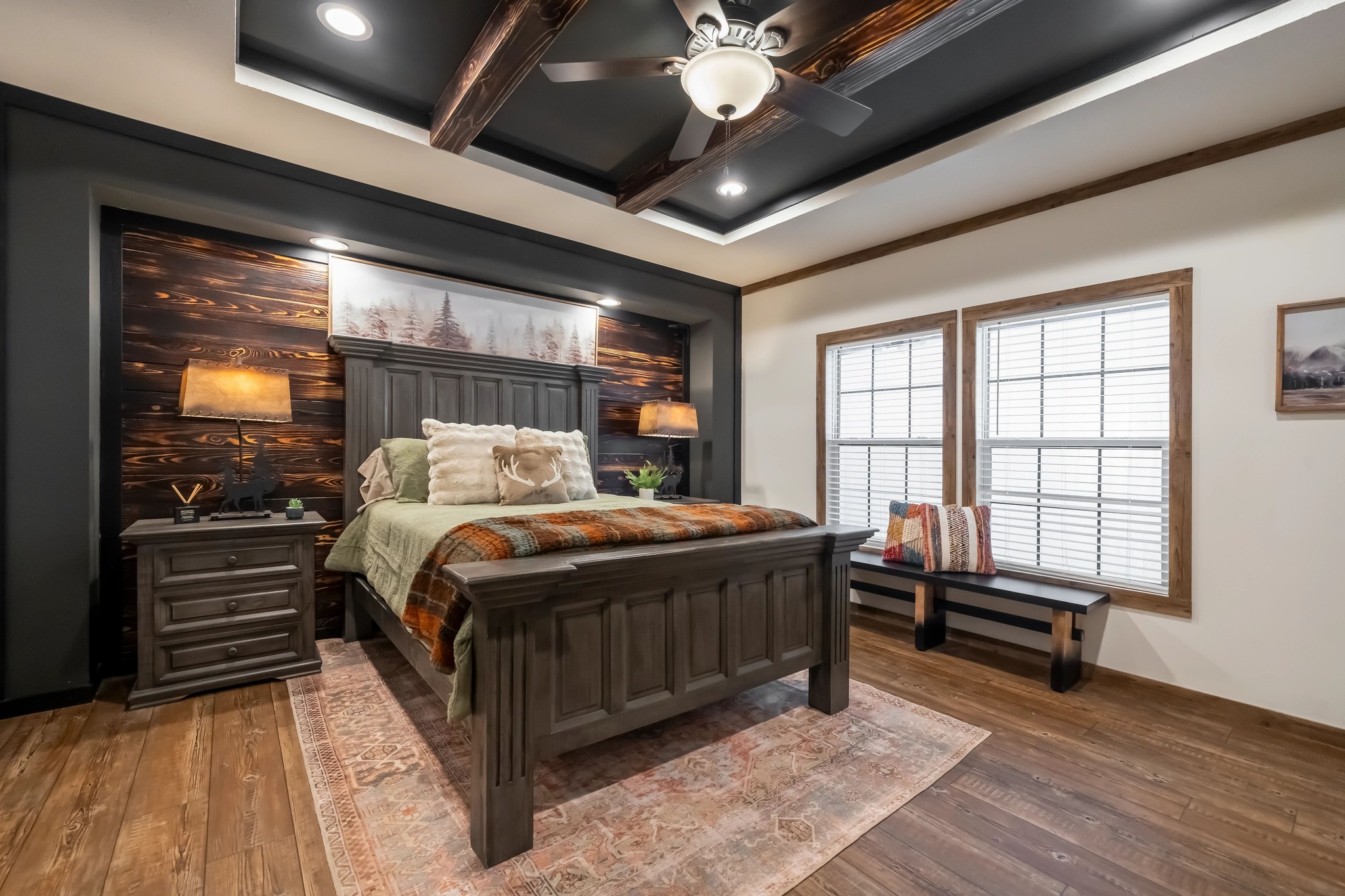 Cozy bedroom with a rustic wood theme features a large wooden bed adorned with pillows and a plaid blanket. Two nightstands with lamps flank the bed.