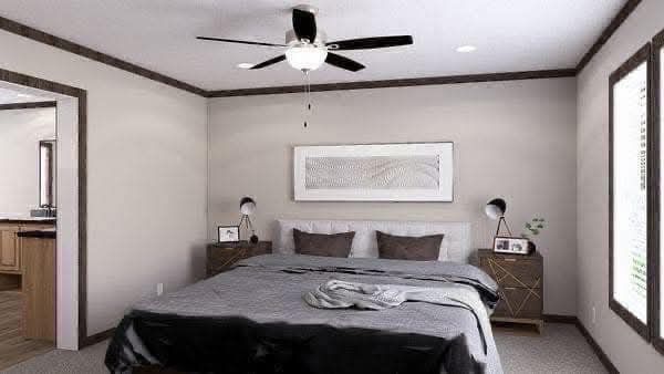 Bright bedroom with a large bed, gray bedding, and two side tables with lamps. A ceiling fan above and a minimalist framed art piece on the wall.