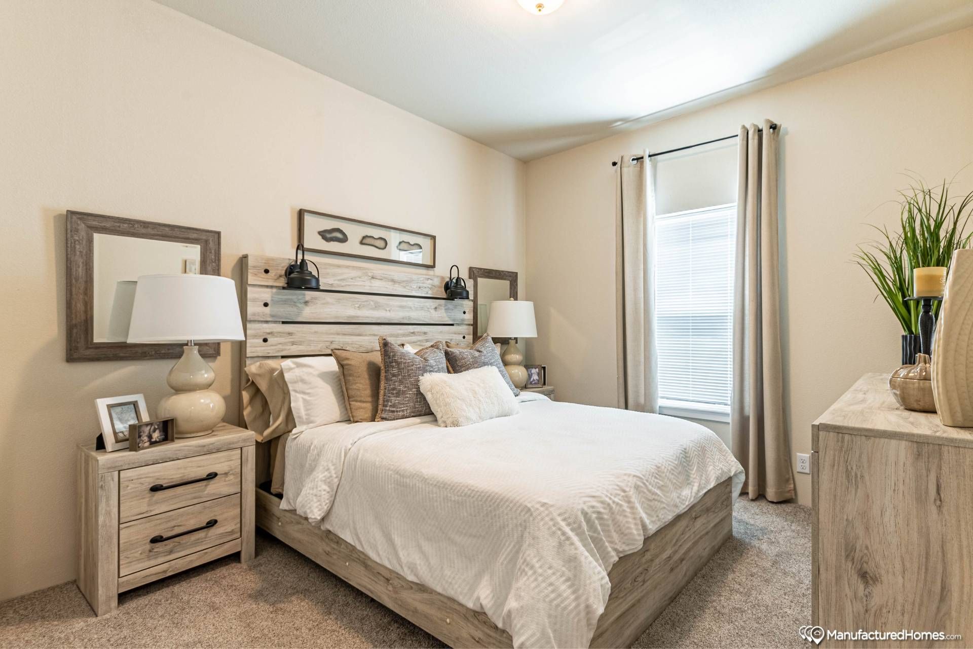 Cozy bedroom with a wooden bed frame, white bedding, and decorative pillows. Two bedside tables have lamps. Neutral tones and a soft, serene ambiance.