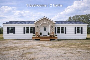 A modern, single-story white house with a stone archway and black shutters sits in a grassy area. Text above reads, "3 bedrooms | 2 baths."