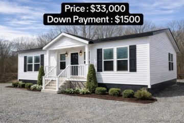 White manufactured home with black shutters, front steps, and small shrubs. Text overlay: "Price: $33,000, Down Payment: $1500." Clear blue sky.