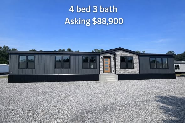 A modern, gray mobile home with a brick accent and multiple windows sits on gravel. Text above reads "4 bed 3 bath, Asking $88,900" under a clear blue sky.
