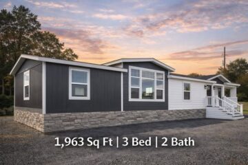 A modern manufactured home with a stone and dark siding exterior is shown at sunset, featuring large windows and a porch. Text reads "1,963 Sq Ft | 3 Bed | 2 Bath."