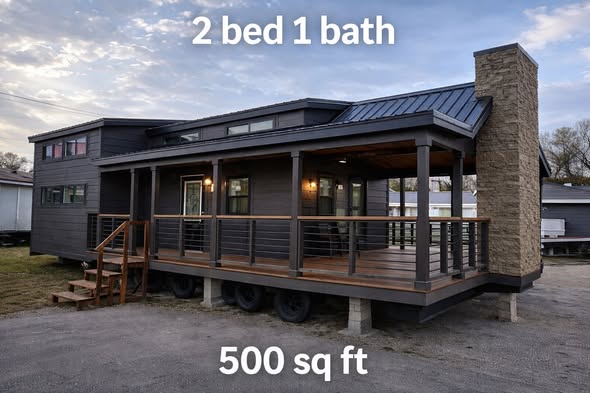 Modern tiny house with dark siding and a covered porch, featuring wood accents and a stone chimney. Text reads: "2 bed 1 bath, 500 sq ft."