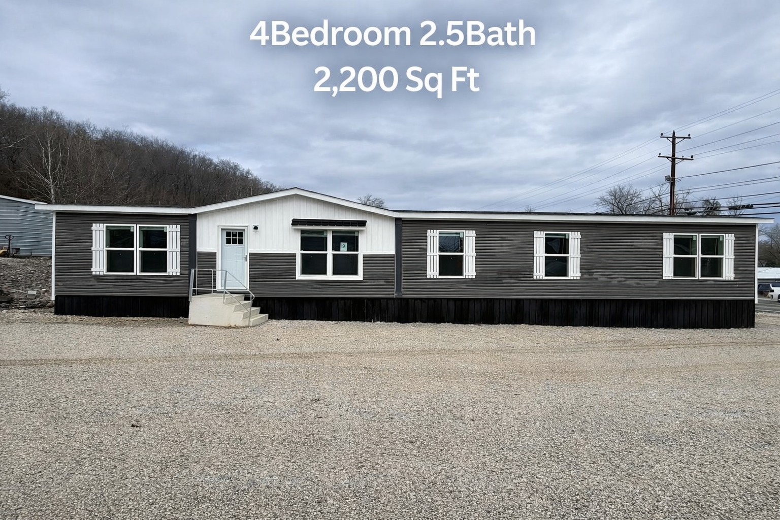 Single-story, grey and white manufactured home in a gravel lot, under a cloudy sky. Text above indicates: 4 Bedrooms, 2.5 Bathrooms, 2,200 Sq Ft.