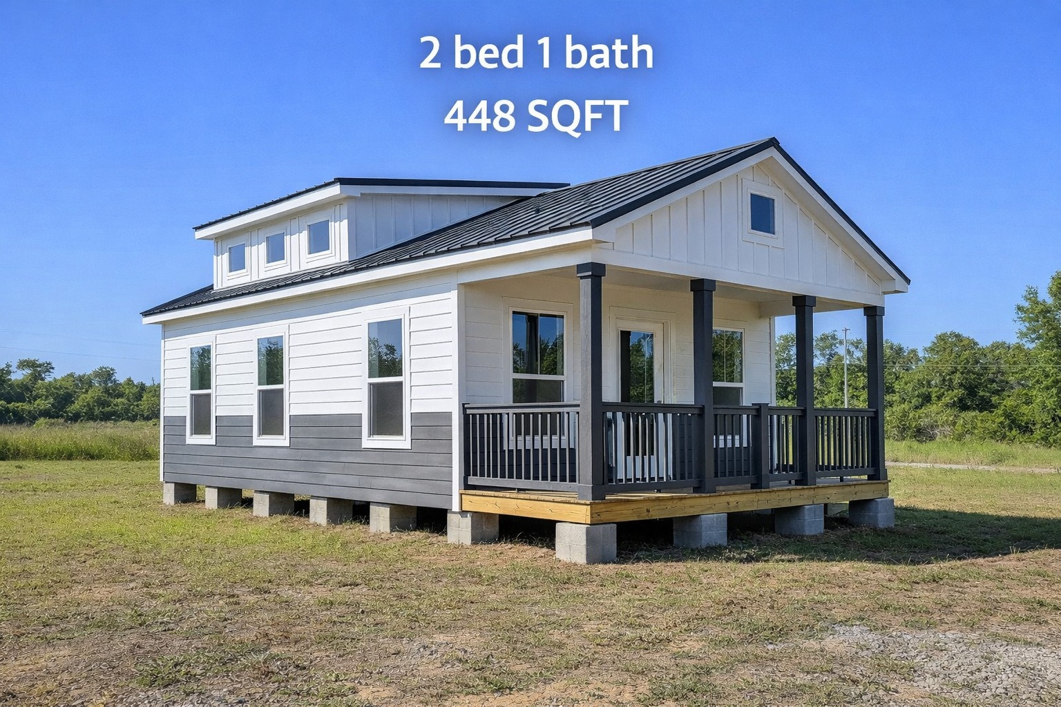 Small house with white siding and dark trim, featuring a front porch. Text reads: "2 bed 1 bath, 448 SQFT." Blue sky and grassy field in background.