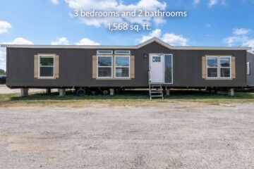 A dark brown mobile home with white trim sits under a blue sky with clouds. It has three windows, a door with steps, and displays "3 bedrooms and 2 bathrooms, 1,568 sq. ft."
