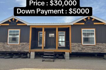 Mobile home with dark siding and stone accents, front porch, and three windows. Price is $30,000 with a $5,000 down payment, displayed prominently.