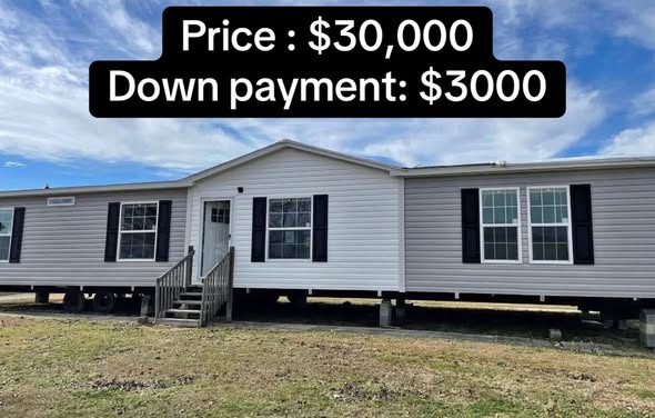 A white and gray mobile home with a gabled roof, featuring black shutters and multiple windows. Text overlay: "Price: $30,000, Down payment: $3,000."
