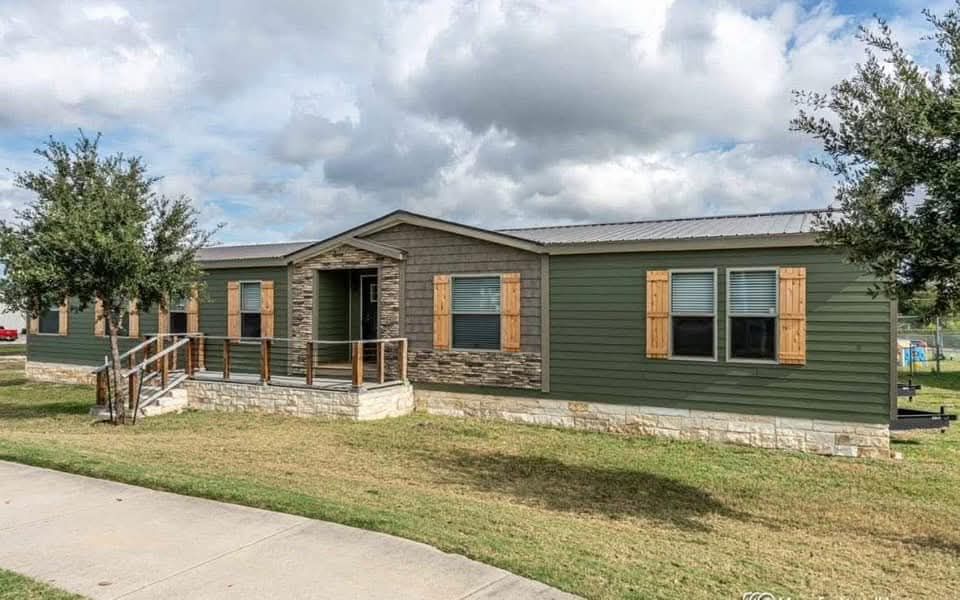 Stylish bedroom with a cozy bed featuring a blue patterned comforter, two dark wood nightstands with lamps, and a soft rug on wooden flooring. Bright and serene ambiance.